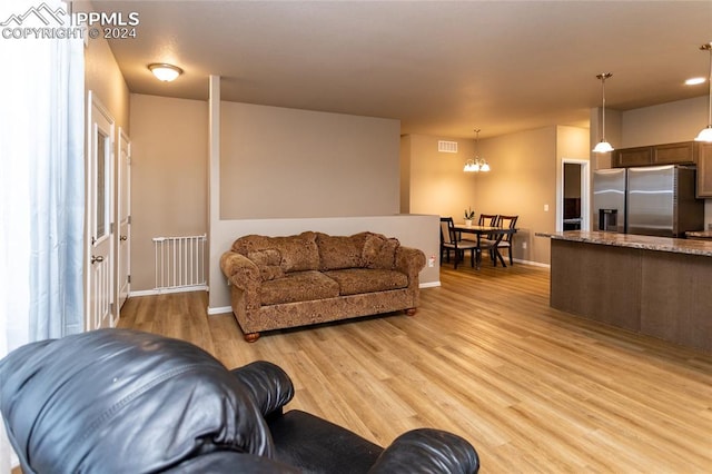 living room featuring light wood-type flooring and a chandelier