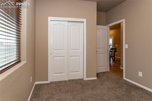 unfurnished bedroom featuring carpet and a closet