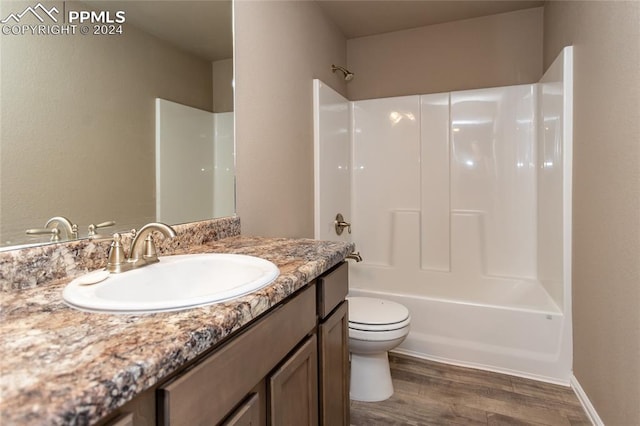 full bathroom with wood-type flooring, toilet, shower / washtub combination, and vanity