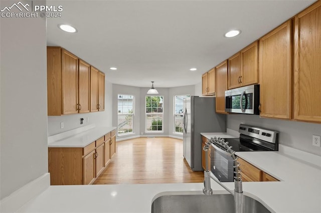 kitchen with appliances with stainless steel finishes, recessed lighting, light wood-type flooring, and light countertops