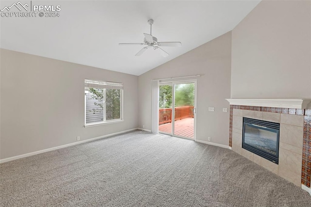 unfurnished living room featuring lofted ceiling, a tiled fireplace, light colored carpet, and ceiling fan