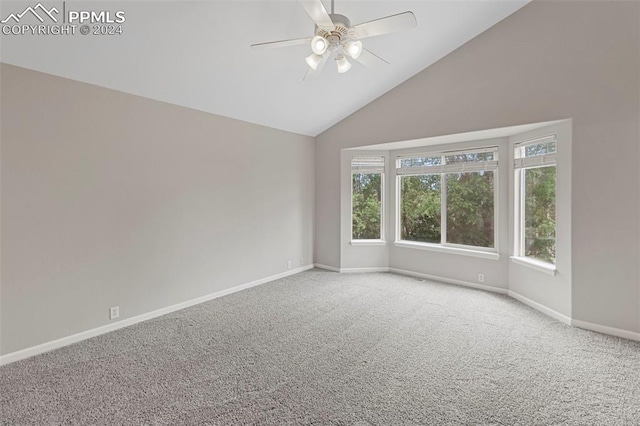 empty room featuring carpet floors, vaulted ceiling, baseboards, and a ceiling fan