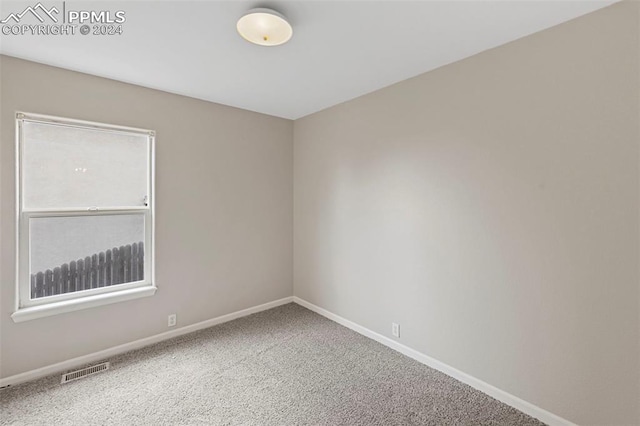 spare room with baseboards, visible vents, and carpet flooring