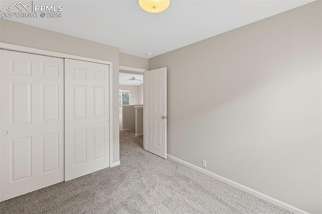 unfurnished bedroom with light carpet and a closet