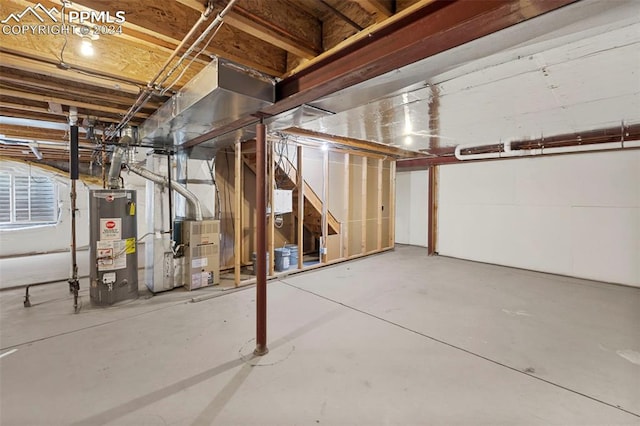 unfinished basement featuring gas water heater and heating unit