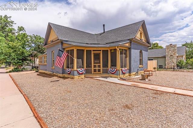 view of front facade featuring a sunroom and roof with shingles