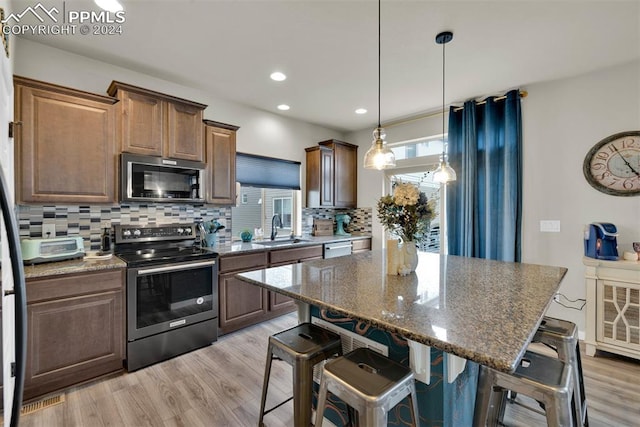 kitchen featuring sink, a breakfast bar area, stainless steel appliances, and a center island