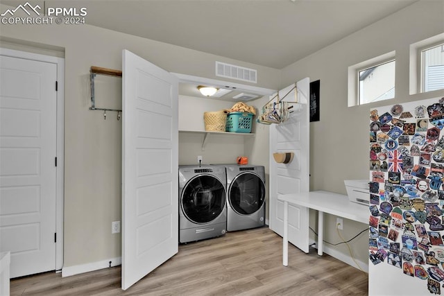 clothes washing area with washing machine and clothes dryer and light hardwood / wood-style floors