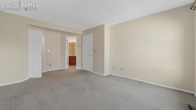 unfurnished room featuring carpet flooring and a textured ceiling