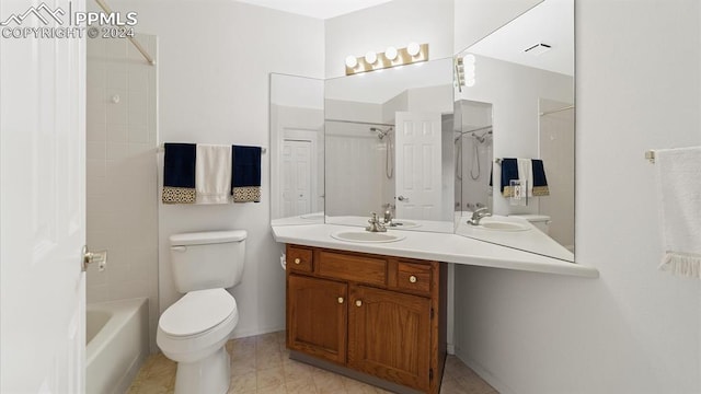 full bathroom featuring tile patterned flooring, toilet, vanity, and tiled shower / bath