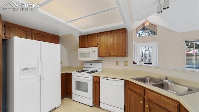 kitchen with lofted ceiling, sink, white appliances, and light tile patterned floors