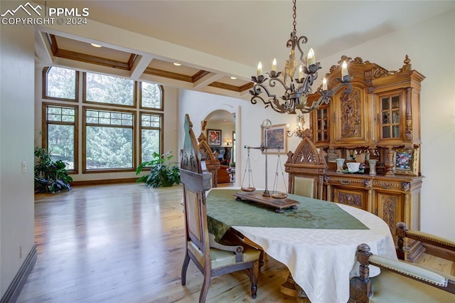 4950 Longwood Pt, Colorado Springs, CO 80906 - dining space with arched walkways, coffered ceiling, baseboards, light wood-style floors, and beamed ceiling