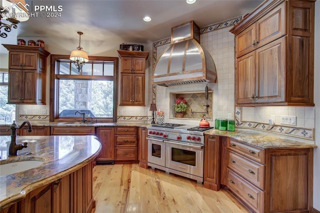 4950 Longwood Pt, Colorado Springs, CO 80906 - kitchen featuring a sink, range with two ovens, light wood finished floors, and custom exhaust hood