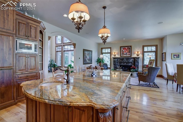 4950 Longwood Pt, Colorado Springs, CO 80906 - kitchen with arched walkways, a sink, open floor plan, a wealth of natural light, and brown cabinets