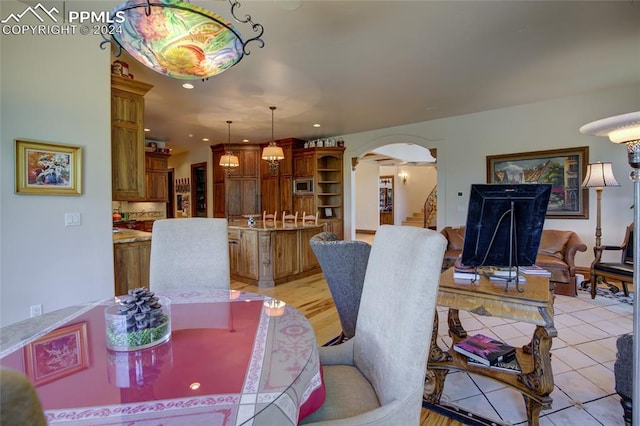 4950 Longwood Pt, Colorado Springs, CO 80906 - dining space featuring arched walkways, light tile patterned floors, and recessed lighting