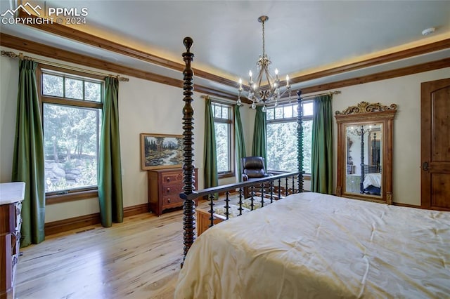 4950 Longwood Pt, Colorado Springs, CO 80906 - bedroom with a raised ceiling, multiple windows, light wood finished floors, and an inviting chandelier
