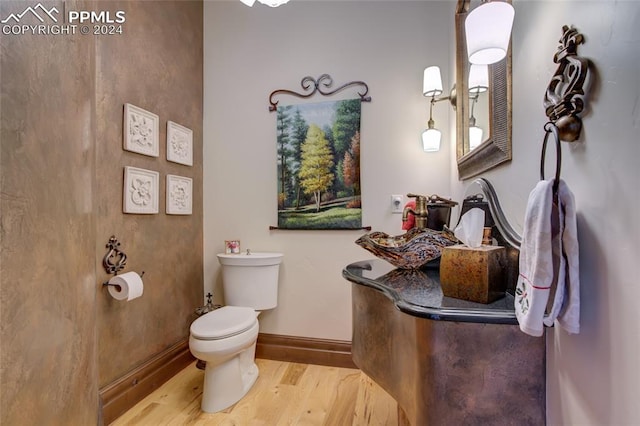 4950 Longwood Pt, Colorado Springs, CO 80906 - bathroom with toilet, baseboards, and wood finished floors
