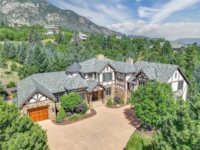 tudor house featuring a garage and a mountain view