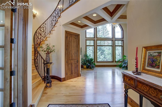 4950 Longwood Pt, Colorado Springs, CO 80906 - foyer featuring a towering ceiling, wood finished floors, coffered ceiling, beamed ceiling, and stairs