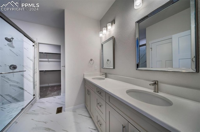 bathroom featuring a shower with shower door and vanity