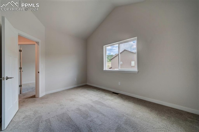 interior space with light colored carpet and vaulted ceiling