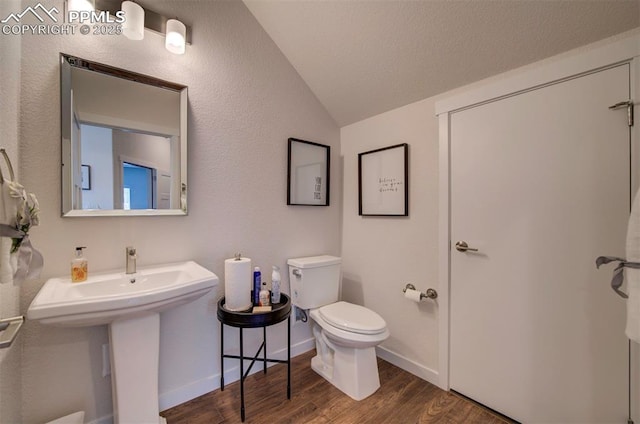 bathroom with sink, wood-type flooring, toilet, and lofted ceiling