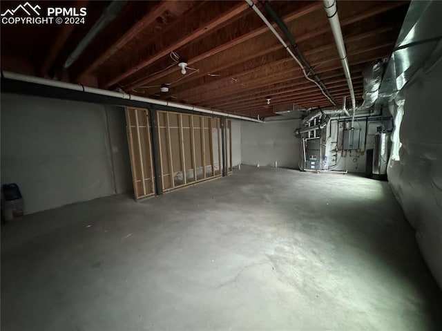 basement featuring heating unit and water heater