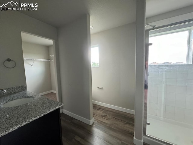 bathroom with hardwood / wood-style flooring, vanity, and an enclosed shower