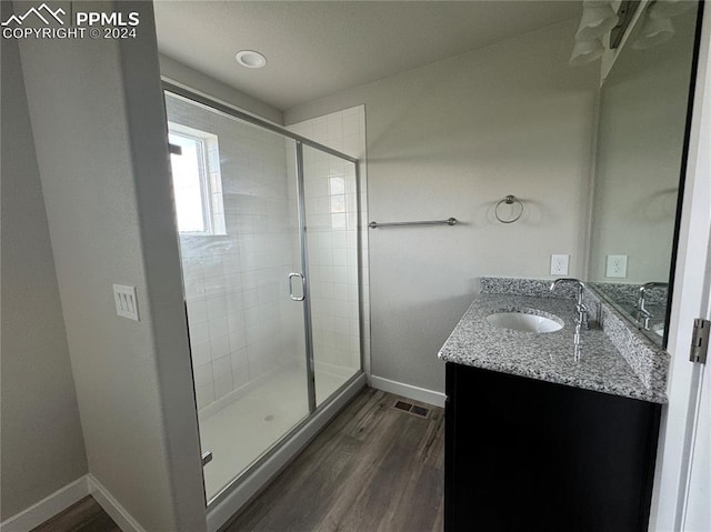 bathroom featuring a shower with door, wood-type flooring, and vanity