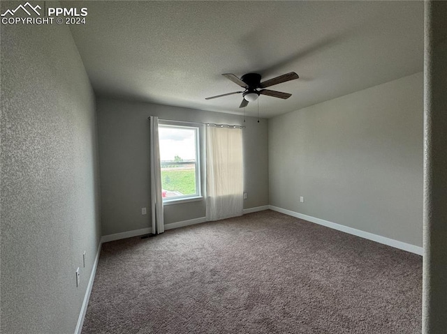 carpeted spare room with a textured ceiling and ceiling fan