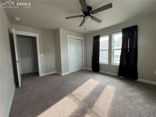 unfurnished bedroom featuring ceiling fan, a closet, and light colored carpet