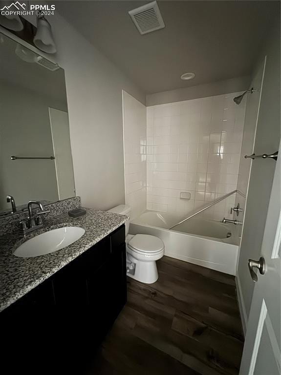 full bathroom featuring toilet, tiled shower / bath, vanity, and hardwood / wood-style floors