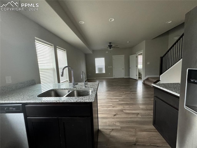 kitchen with ceiling fan, sink, dark wood-type flooring, stainless steel appliances, and light stone counters