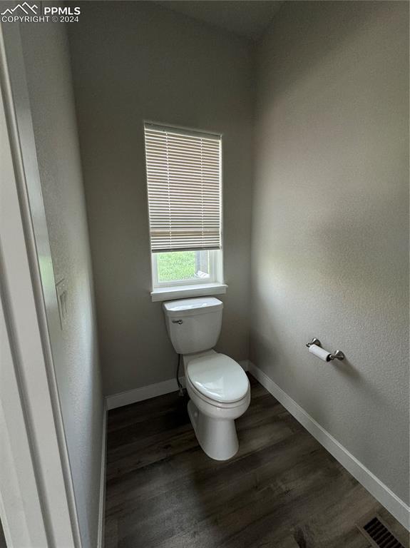 bathroom with hardwood / wood-style floors and toilet