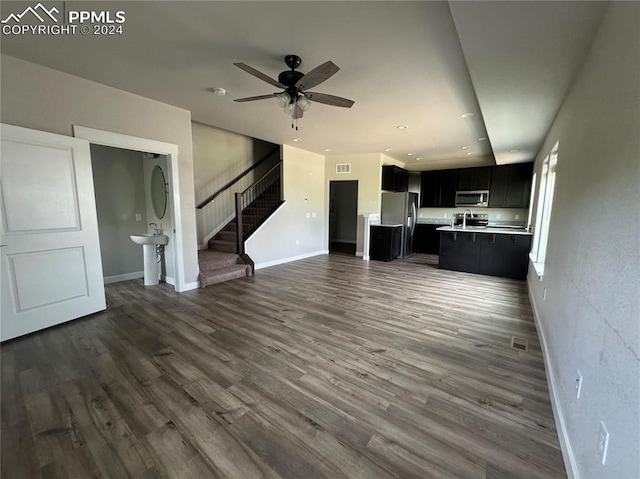 unfurnished living room featuring ceiling fan, dark wood-type flooring, and sink