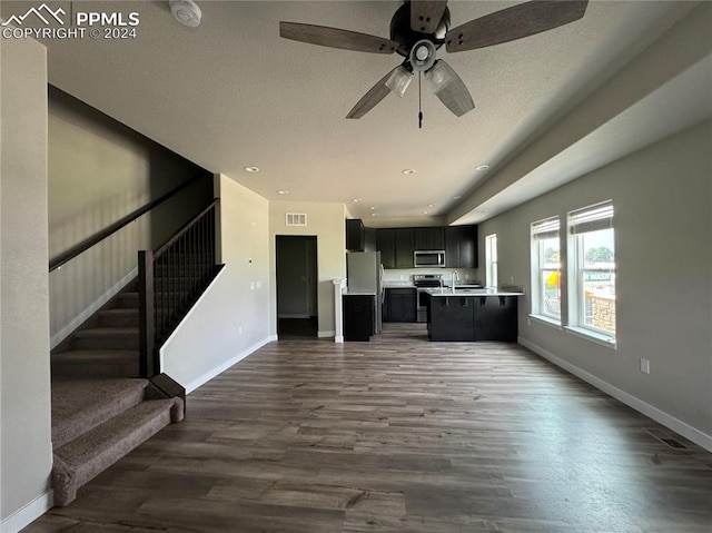 unfurnished living room with ceiling fan and dark hardwood / wood-style flooring