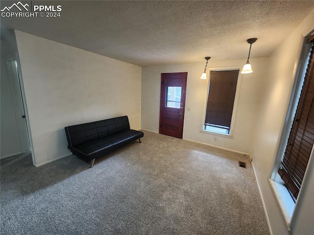 foyer entrance with a textured ceiling and carpet flooring