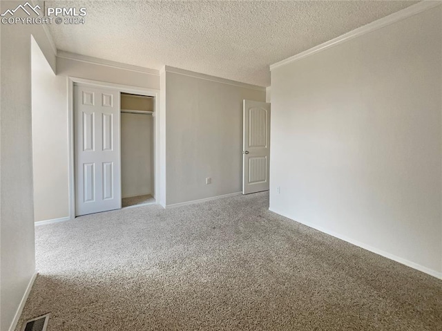 unfurnished bedroom featuring crown molding, a closet, carpet flooring, and a textured ceiling