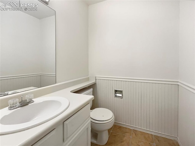 bathroom with toilet, tile patterned flooring, and vanity