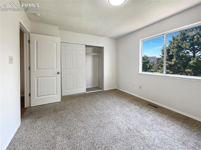 unfurnished bedroom with a closet, a textured ceiling, and carpet floors