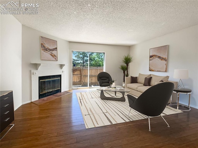 living room featuring dark wood-type flooring and a textured ceiling