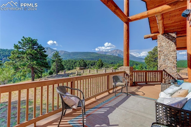 wooden deck featuring a mountain view and a view of trees