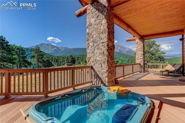 deck featuring hot tub deck surround and a mountain view