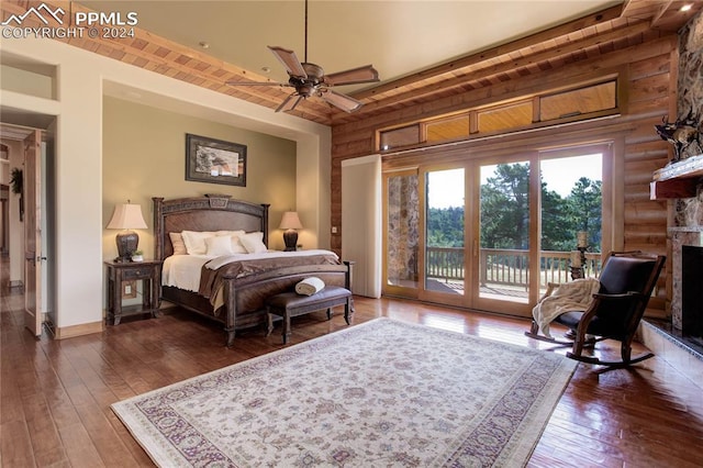 bedroom featuring access to outside, a fireplace, baseboards, and hardwood / wood-style floors