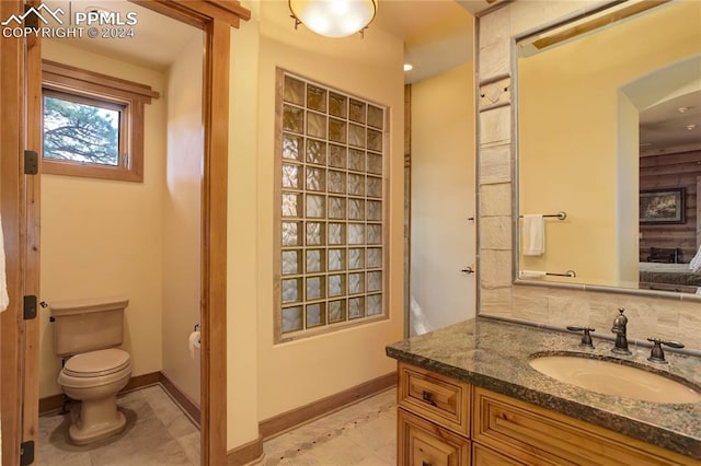 bathroom with vanity, toilet, and baseboards