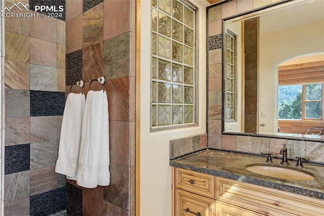 bathroom featuring a tile shower and vanity