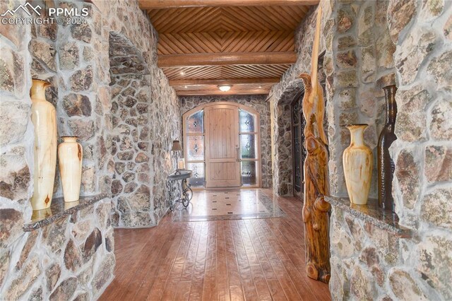 foyer with beam ceiling, hardwood / wood-style flooring, and wood ceiling