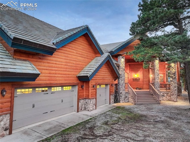 view of front of property featuring a garage and stone siding