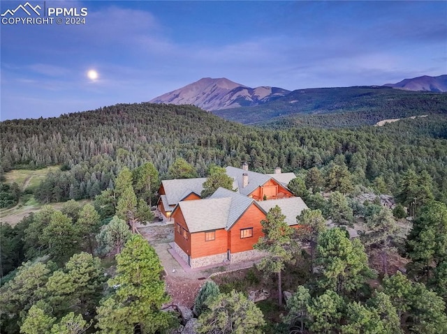 drone / aerial view with a mountain view and a view of trees