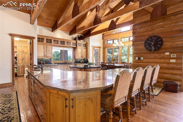 kitchen featuring a spacious island, wooden ceiling, high vaulted ceiling, and tasteful backsplash